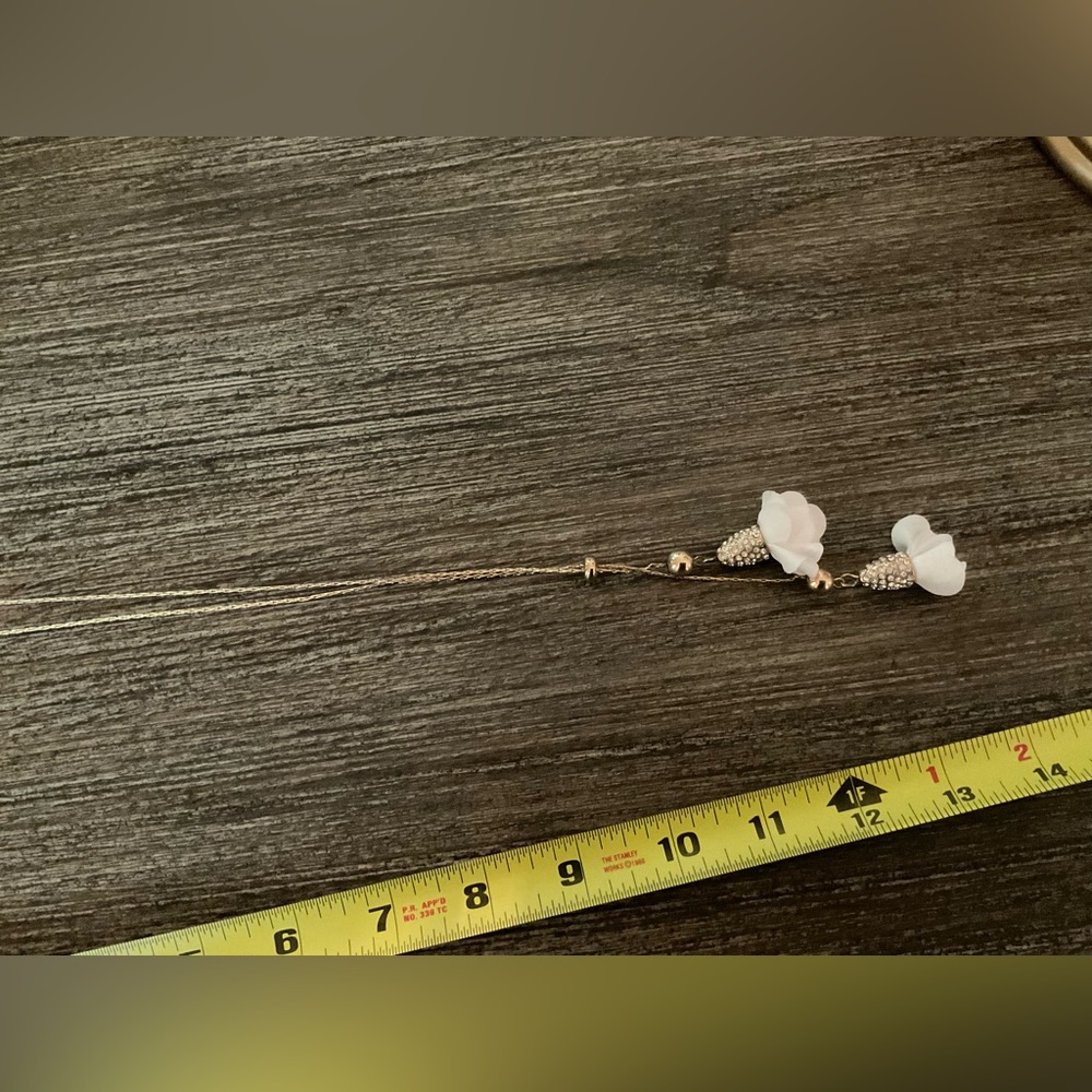 Long gold necklace; rhinestones to drop white flowers